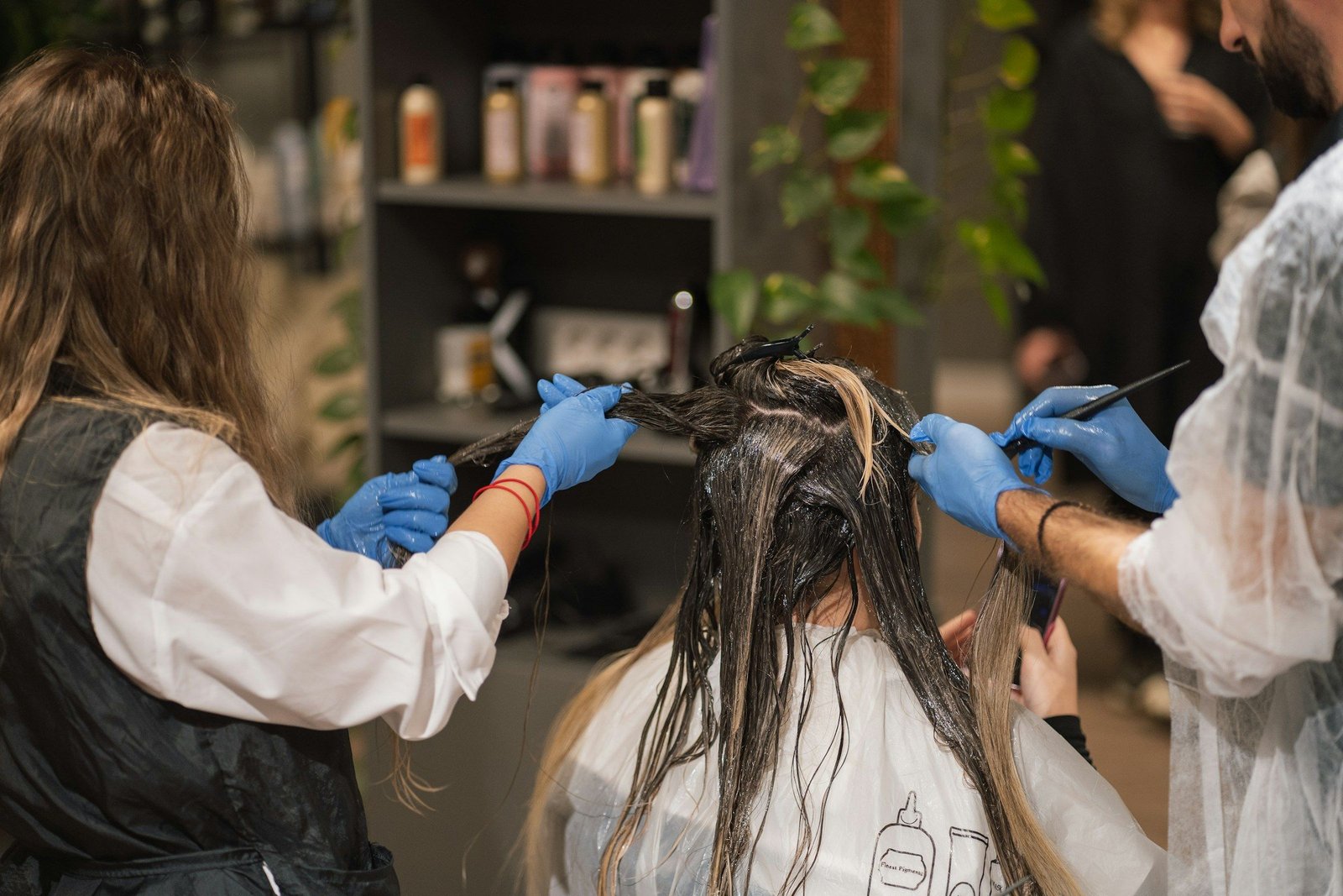 Two colorists applying hair color in the salon